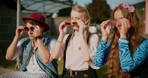 Stylish Young Adults Putting on Sunglasses