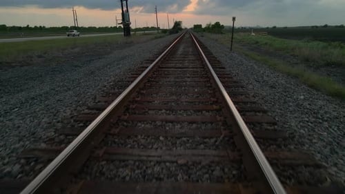 Drone Shot Tracking Very Low Over Railroad Track And Lifting Up High Over Power Lines And Road In Te