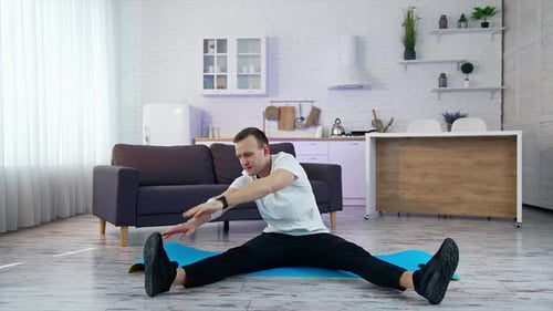 Young Adult Stretching on Exercise Mat at Home