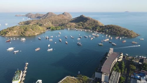 Aerial view of Labuan Bajo is filled with traditional boats Pinisi schooner sailing on the ocean.