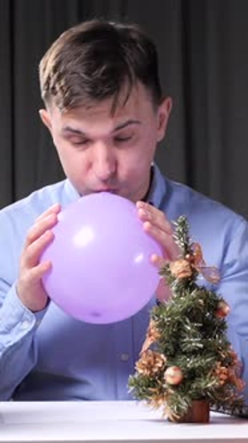 Vertical Video Office Worker Inflating Balloon at Christmas Time Stack Folders