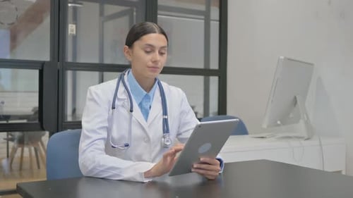 Female Doctor Using Tablet in Modern Office