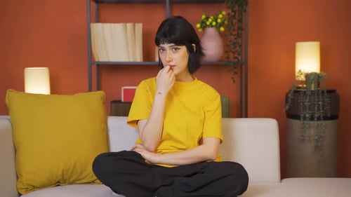 The young woman is biting her nails.