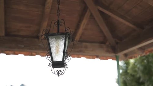 Elegant Light Fixture with Ornate Design Hanging Outdoors