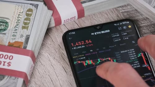 Trader Analyzes Ethereum Cryptocurrency Prices on Smartphone Near Dollars
