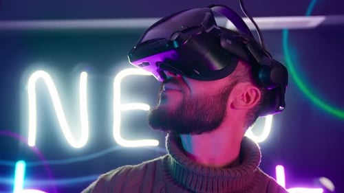Man Wearing VR Headset in Neon Lit Room