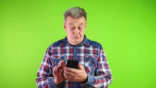 Man Uses Smartphone With Confused Expression