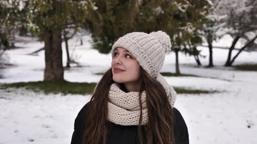 Glückliche Frau geht im Winterwald spazieren
