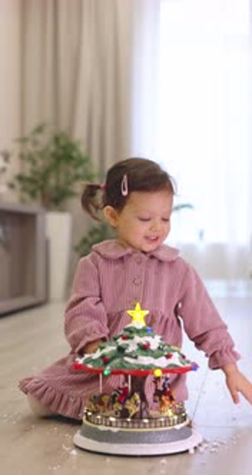 Child Girl Sprinkles Christmas Musical Carousel Toy with Snow at Home