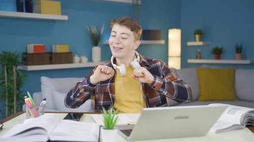 Young Adult Studying at Home with Laptop and Books
