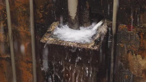 Water Pouring onto Grimy Metal Surface