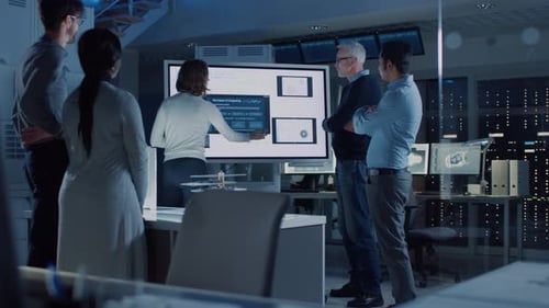 Team of Professionals Analyzing Technology Data on Screen