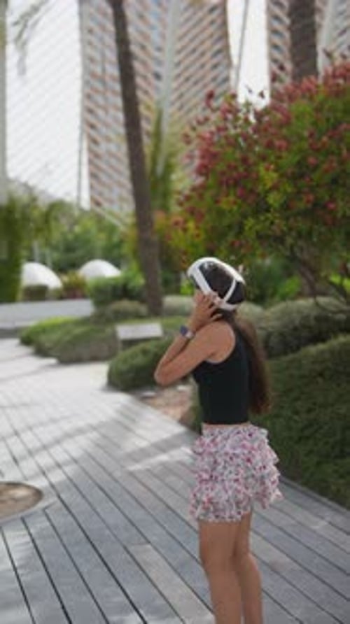 A Woman is in a Park Using Virtual Reality to Immerse Herself in Nature and Feel Joy