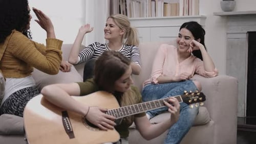 Grupo de amigas toca violão na sala de estudantes