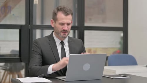 Businessman Working at Laptop Gets a Headache