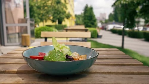 Vertical Video Closeup in Restaurant on the Street on a Wooden Table the Chef Puts on the Table a