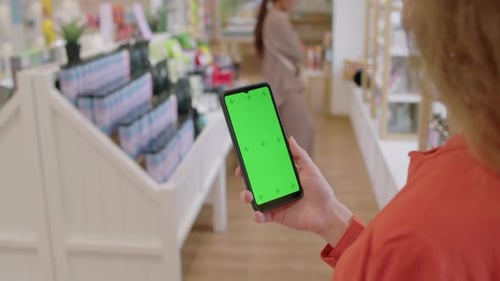 Unrecognizable Woman Using Smartphone during Shopping in Cosmetics Store