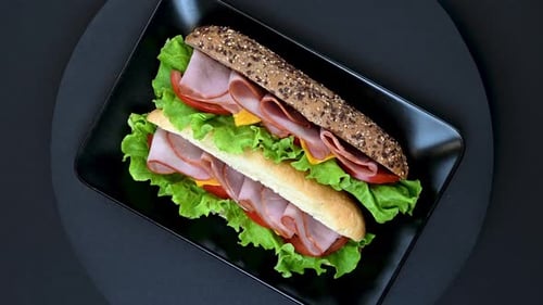 Delicious Ham and Cheese Sandwich Rotating on Plate