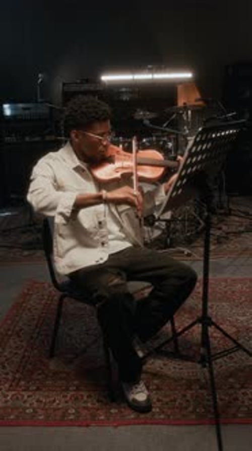 Young Man Plays Violin in Music Studio