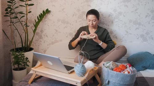 Woman Crochet on Bed with Laptop and Yarn