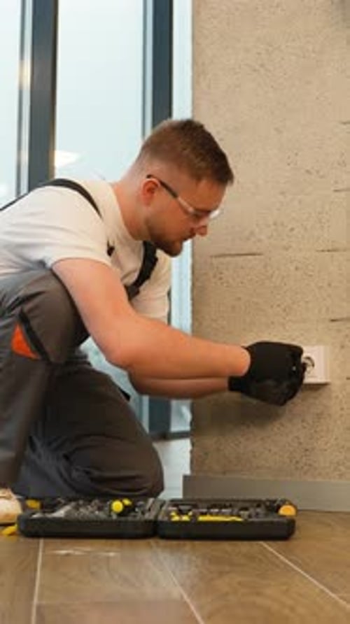 Man Installs Electrical Outlet in Modern Interior