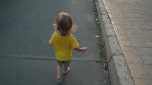 Baby Walking Barefoot on Cracked Pavement