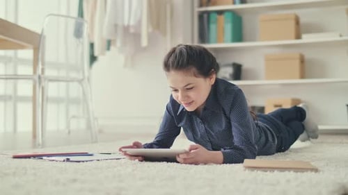 Happy Girl Using Tablet at Home on Rug