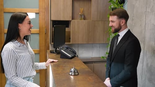 Hotel Receptionist Giving Room Key Card to Guest at Check in