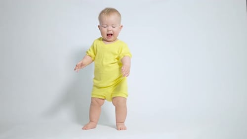 the baby diligently takes the first steps while maintaining balance