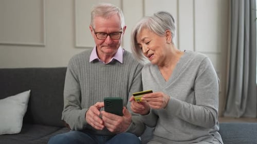 Senior Couple Man Woman Shopping Online with Smartphone Paying with Credit Card Old People Buying on