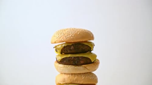 Tall Stack of Cheeseburgers on a Cutting Board
