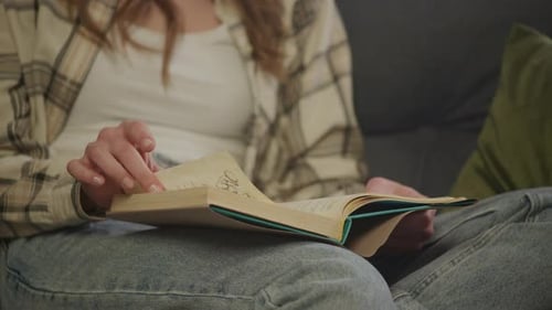Woman Turns Pages of Novel Indoors