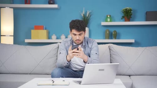 Man Using Mobile Phone at Home on Couch