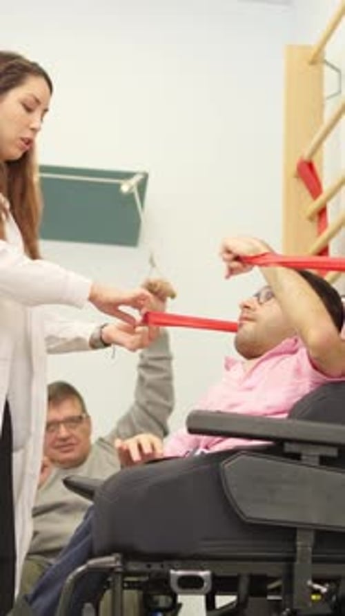 Woman Assists Man with Exercise Band in Rehabilitation