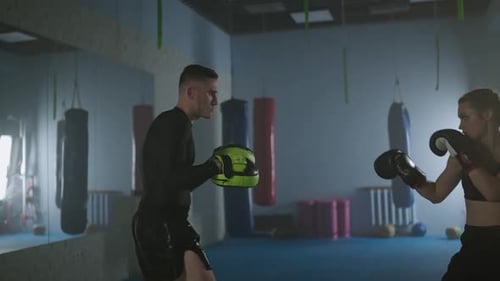 Woman Boxing with Trainer in Boxing Gym