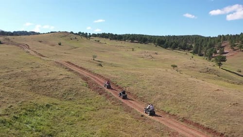Atv Riders Driving Offroad Along Mountain Road With Aerial Shot