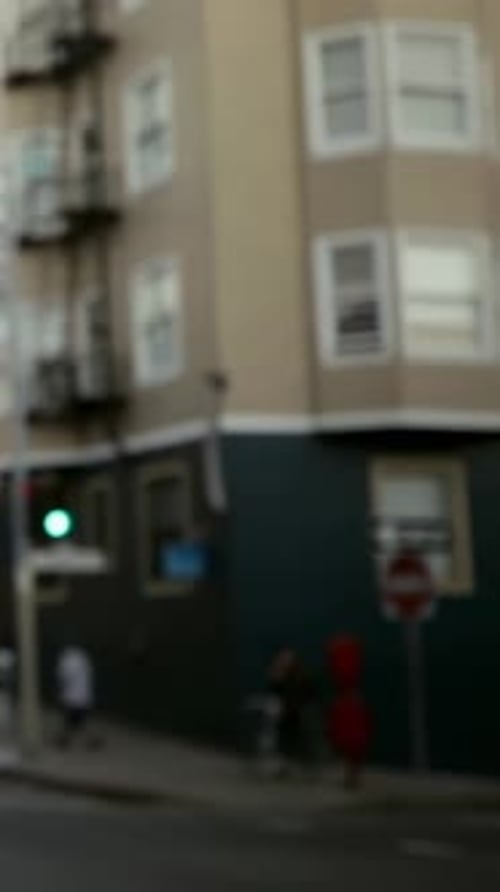 Vertical video: Walking pair red and dark clothes moving curb after green, cart nearby, copy space