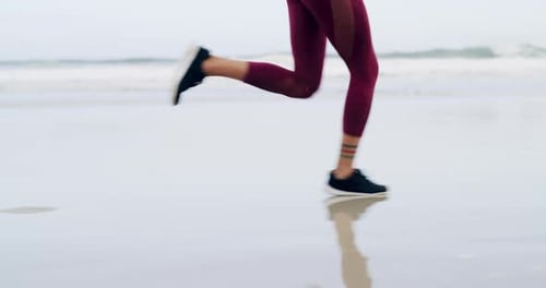 4k video footage of an unrecognizable sportswoman running on the beach