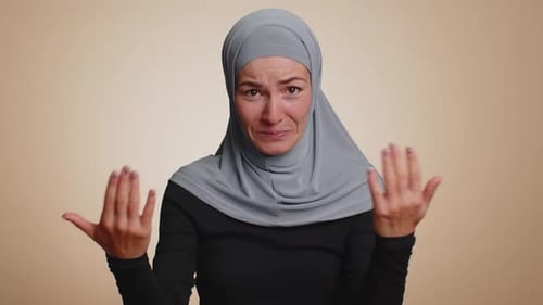 Muslim Woman in Hijab Smiling Friendly at Camera Nods Her Head Gesturing Hello Hi Assalamu Alaikum