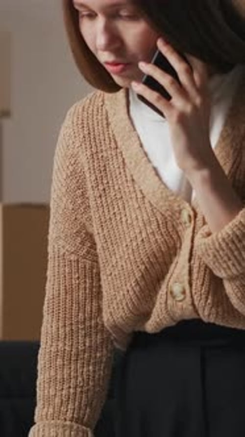 Woman Talks on Phone Working at Laptop