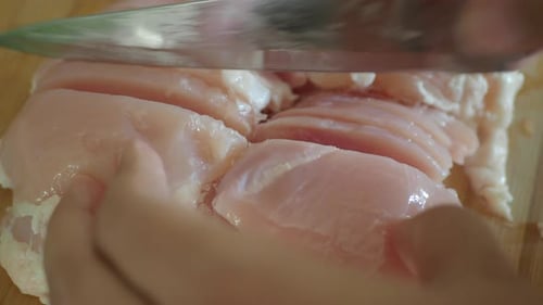 Hähnchenfilet auf einem Schneidebrett schneiden