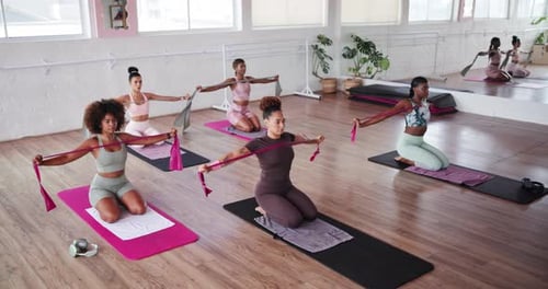 Exercise class, pilates and resistance band with people in studio for fitness or training together