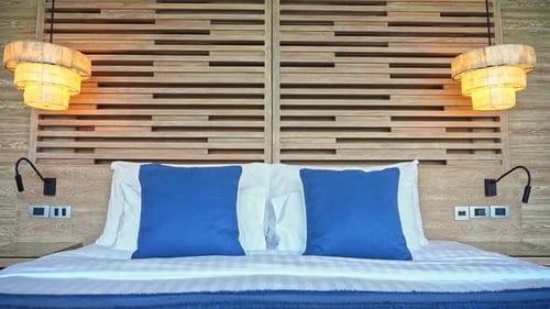 Pedestal down of tidy and clean white and blue double bed in hotel room