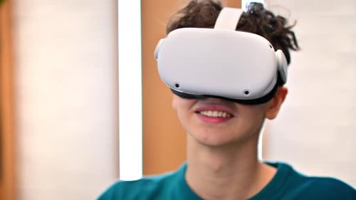 A young excited caucasian man taking off VR glasses in an office