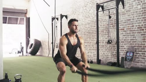 Man, battle ropes and exercise strength for arm workout in gym for cardio performance