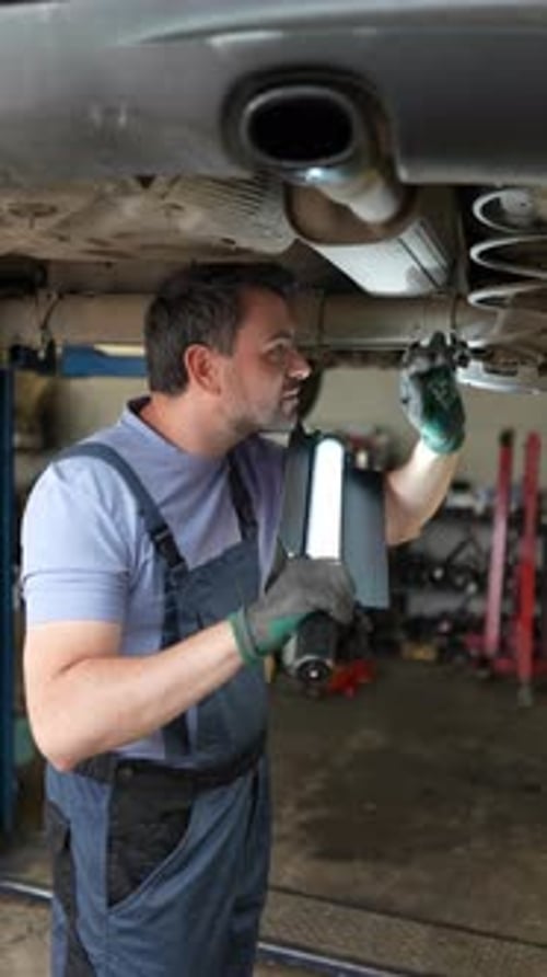 Car repair technician checking engine bay