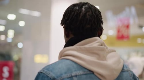 Black Man Denim Jacket Hoodie Walking in Shopping Mall Interior