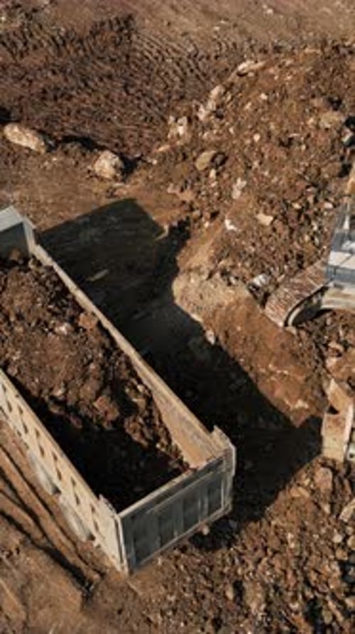 Excavator Loading Dirt Into Truck, Aerial View