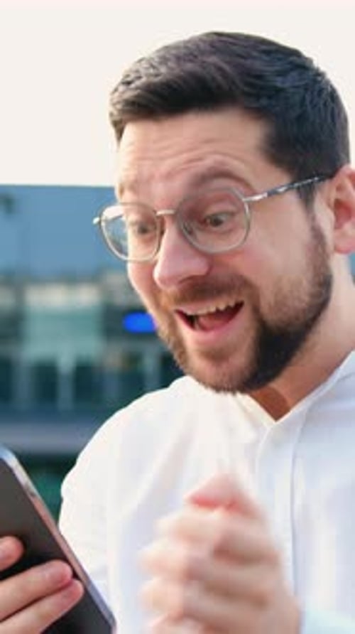 Excited Man Reacting to Good News on Phone