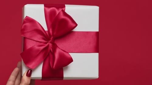 Gift With a Red Ribbon Being Held